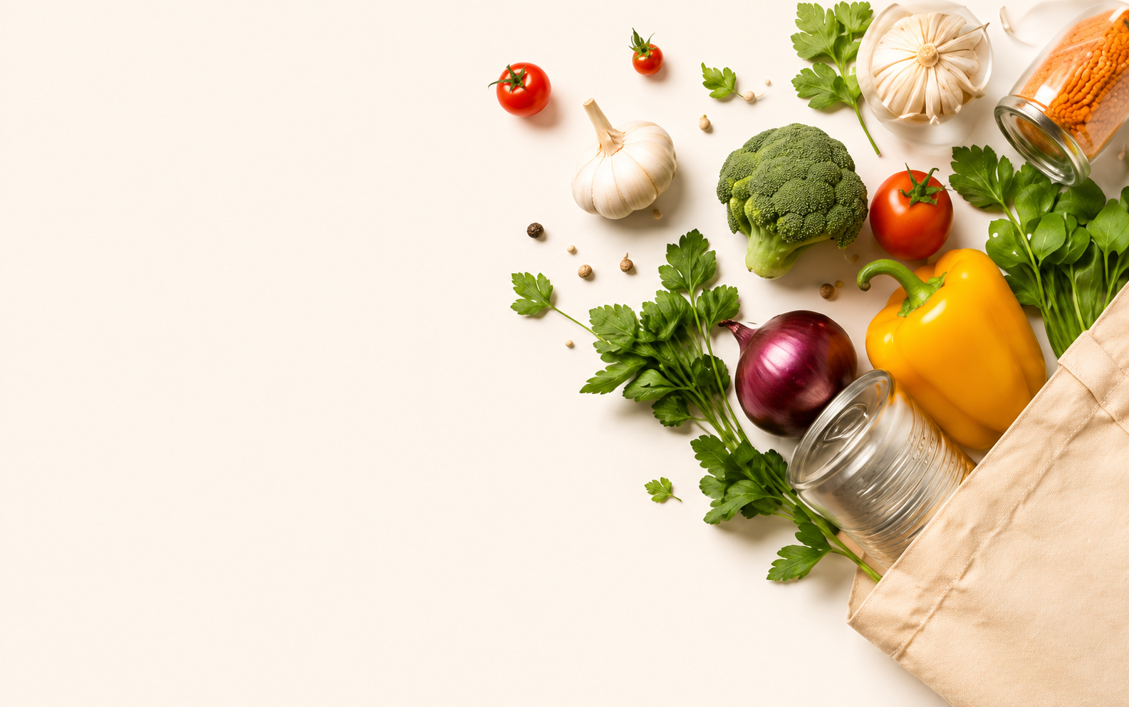 Fresh produce — garlic, tomatoes, broccoli, herbs and a yellow pepper — arranged on a warm cream surface, spilling from a canvas tote bag